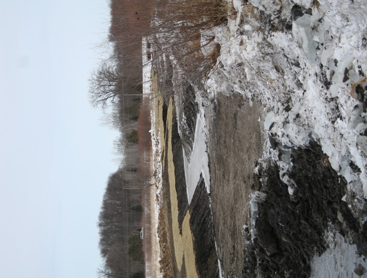 Frozen water in channel, reinforced banks and snow 